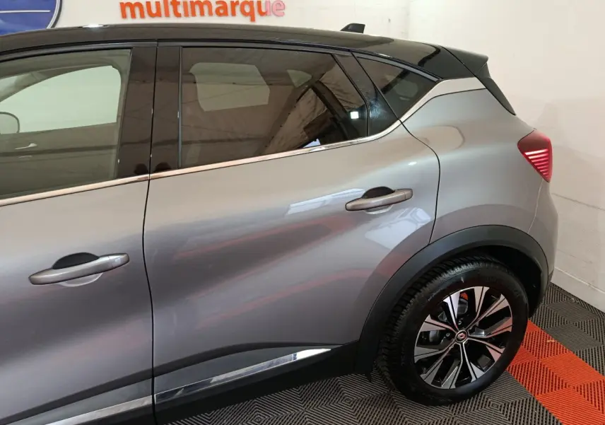 Vue latérale droite du Renault Captur techno TCe 90 gris foncé, mettant en valeur la jante alliage et les lignes de caisse.