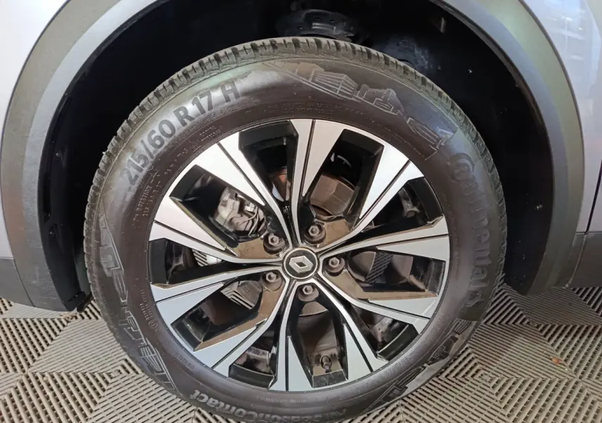 Gros plan sur la roue avant gauche du Renault Captur gris foncé, mettant en valeur la jante alliage moderne et le pneu Continental.