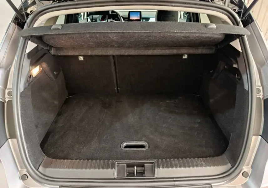 Coffre ouvert du Renault Captur Techno TCe 90 gris foncé, vue arrière avec tablette cache-bagages relevée.