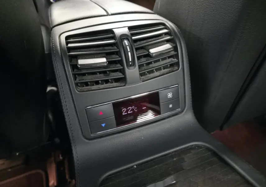 Vue rapprochée de la console centrale arrière avec commandes de climatisation affichant 22°C dans une Mercedes CLS gris.