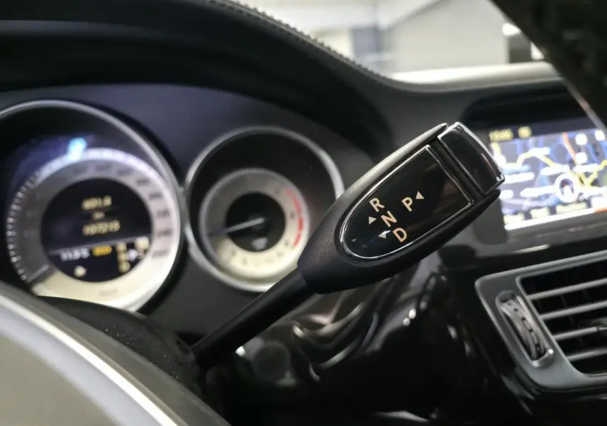 Le levier de boîte automatique 7G-Tronic Plus de la Mercedes CLS 250 CDI gris, avec tableau de bord et écran de navigation visibles.