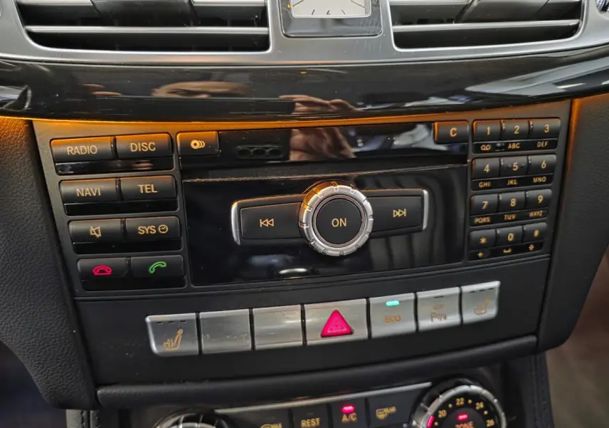 Gros plan sur la console centrale noire de la Mercedes CLS 250 CDI 2011 avec commandes audio et climatisation THERMOTRONIC.