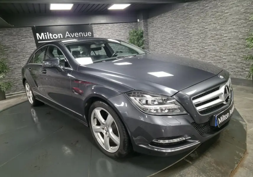 Mercedes Classe CLS gris métallisé vue 3/4 avant droit avec jantes alliage 5 branches en intérieur showroom.