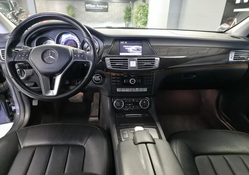 Intérieur noir cuir de la Mercedes CLS 250 CDI 2011, vue frontale sur le tableau de bord et volant multifonctions.