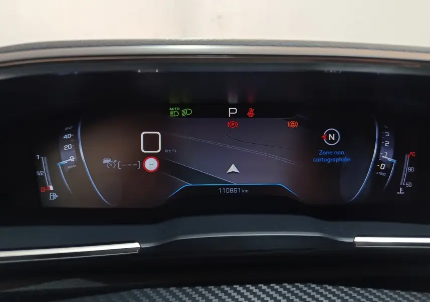 Vue rapprochée du tableau de bord numérique de la Peugeot 508 gris clair, affichant la vitesse, la navigation et les alertes.