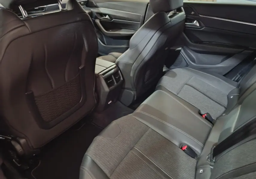 Vue intérieure arrière côté droit de la Peugeot 508 2020 gris clair, sièges mixtes cuir et tissu avec console centrale et aérateurs.