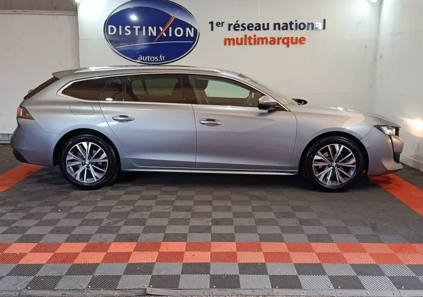 Peugeot 508 BlueHDi gris clair vue de profil côté gauche, break élégant avec jantes alliage et vitres teintées.