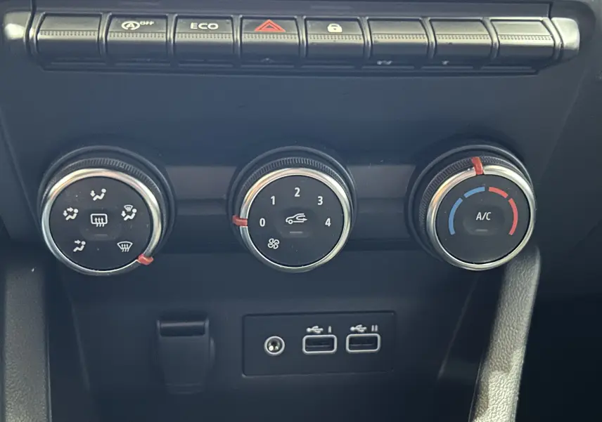Détail de la console centrale de la Renault Clio V blanche, montrant les commandes de climatisation et deux ports USB.
