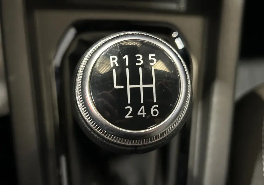 Gros plan sur le pommeau de la boîte manuelle 6 vitesses de la Renault Clio V, intérieur noir.