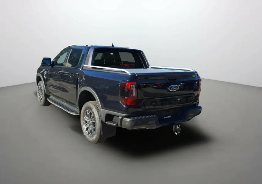Ford Ranger noir agate vu en 3/4 arrière droit avec benne et attelage visible sur fond neutre.