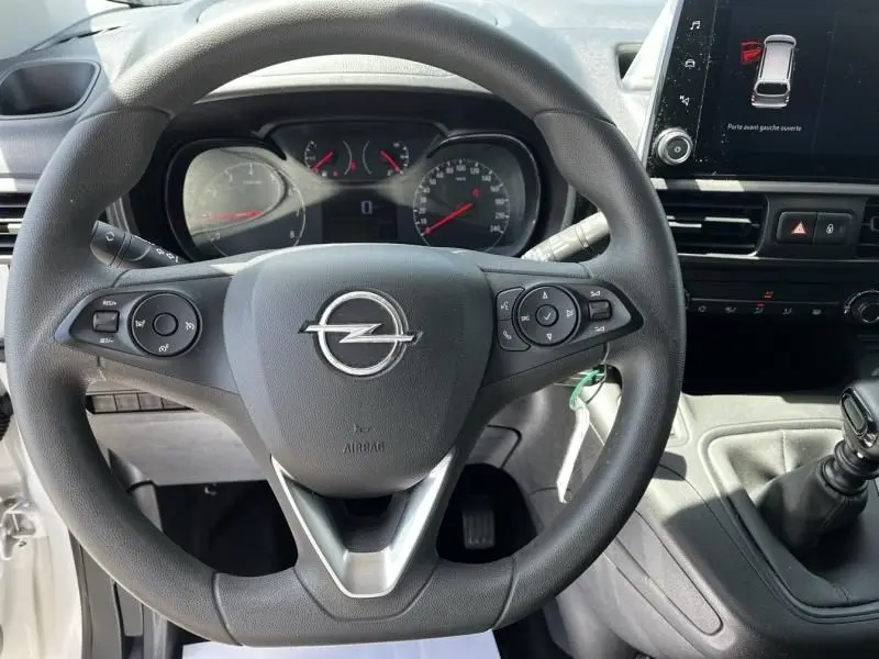 Vue intérieure centrée sur le volant d’un Opel Combo Cargo blanc 2024, avec tableau de bord et écran tactile visible.