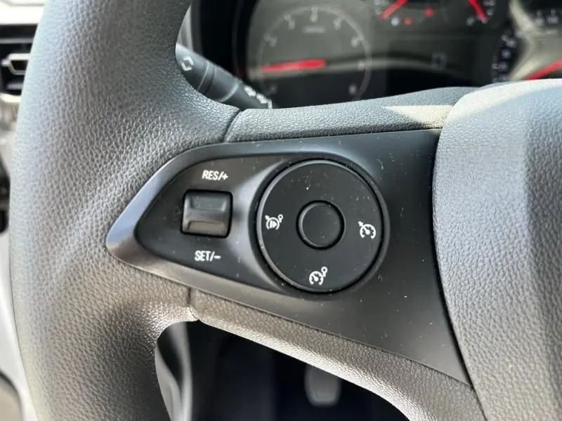 Gros plan sur les commandes de régulateur de vitesse au volant d’un Opel Combo Cargo blanc 2024, version diesel.