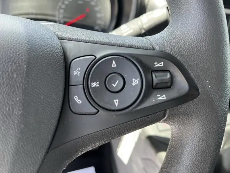 Gros plan sur les commandes multifonctions noires à droite du volant de l’Opel Combo Cargo blanc, version 2024.