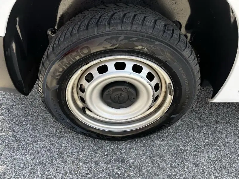 Gros plan sur la roue avant gauche d’un Opel Combo Cargo blanc 2024 avec jante acier et pneu hiver Kumho.