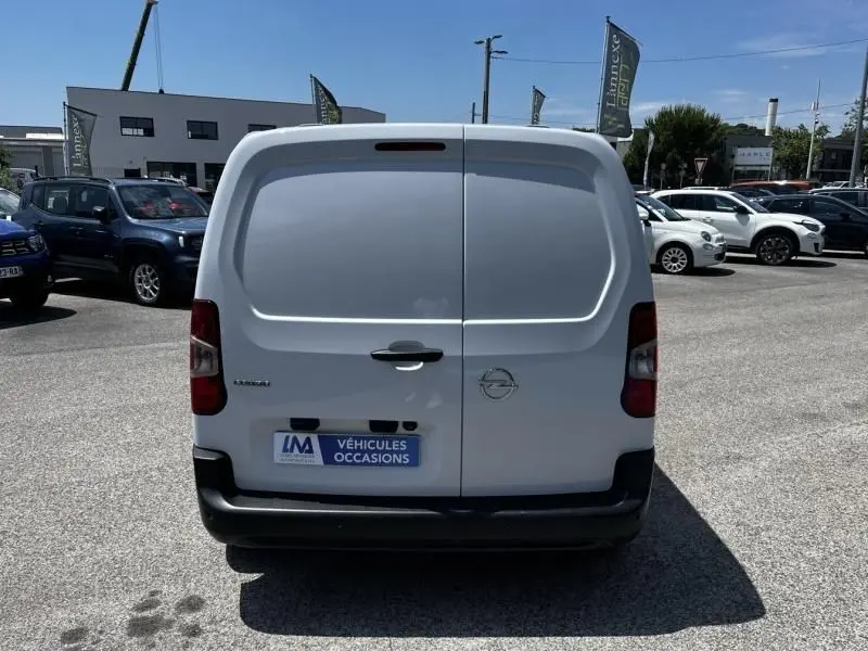 Vue arrière d’un Opel Combo Cargo blanc 2024, fourgon utilitaire avec portes battantes et logo Opel visible.