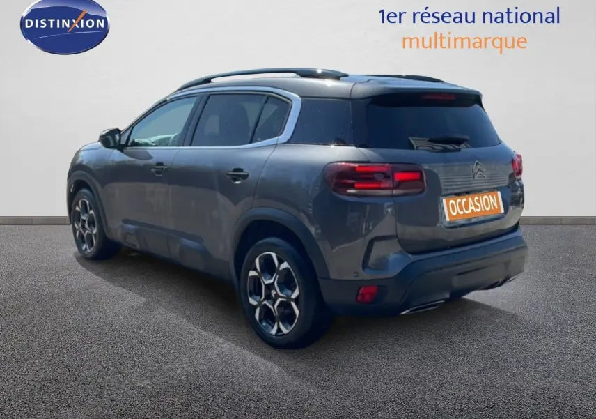 Vue 3/4 arrière droite d'un Citroën C5 Aircross gris platinium métallisé avec jantes bi-ton et toit noir.