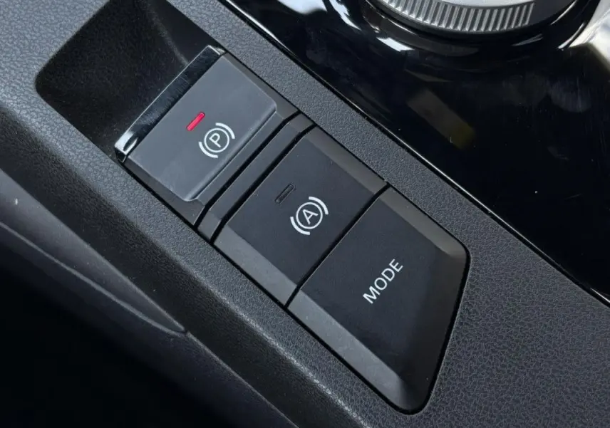 Détail intérieur montrant les boutons de frein à main électronique et mode de conduite du MG3 blanc Dover 2025.