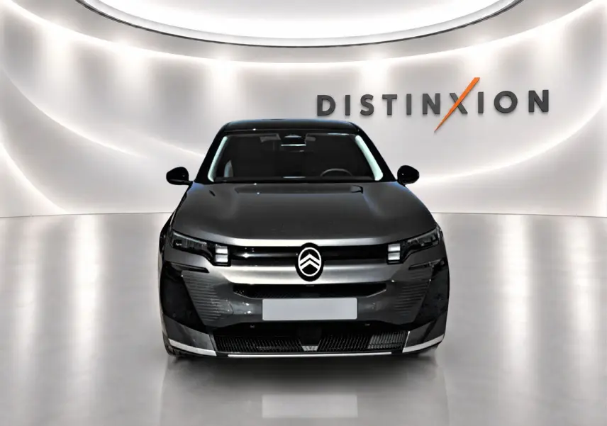 Citroën C5 Aircross gris platinium vue de face, avec toit noir et logo distinctif sur fond lumineux "Distinxion".