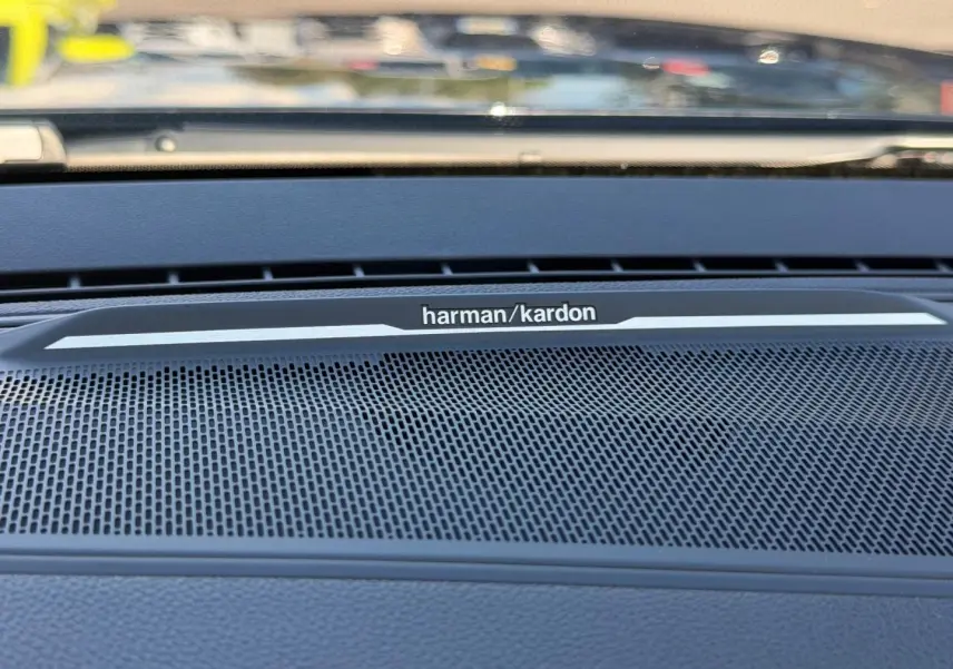 Gros plan sur la grille haut-parleur Harman Kardon intégrée au tableau de bord du Renault Austral noir étoilé.
