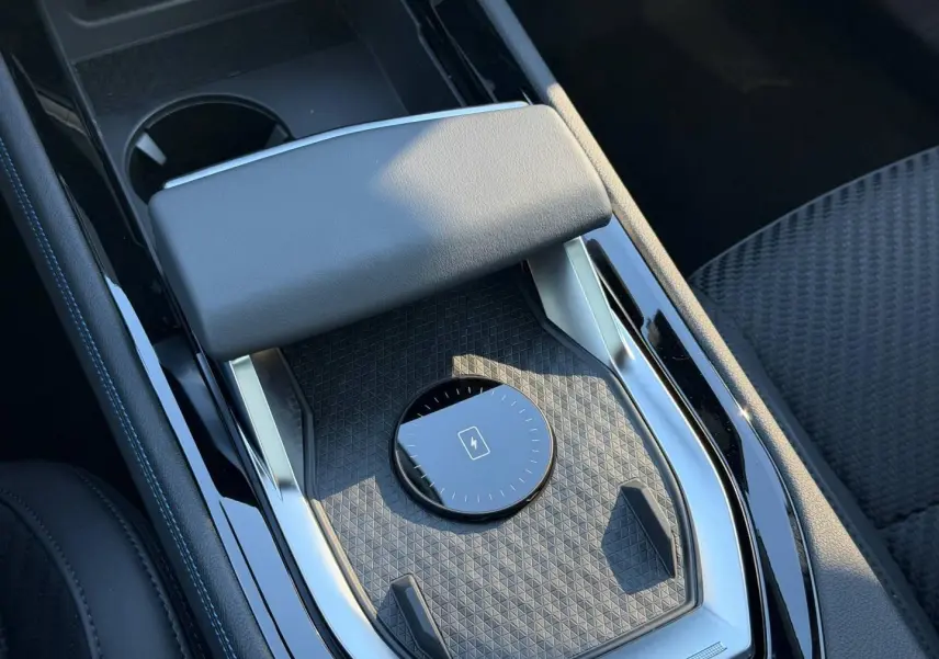Gros plan sur la console centrale noire étoilé métallisé du Renault Austral avec accoudoir et surface texturée.