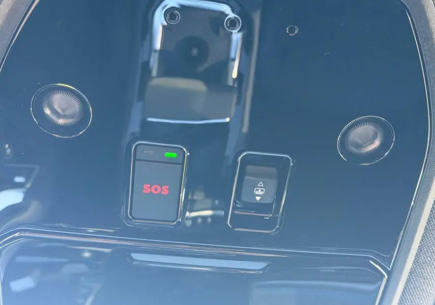Gros plan sur la console de toit noire brillante du Renault Austral 2026 avec bouton SOS rouge et commande de toit ouvrant.