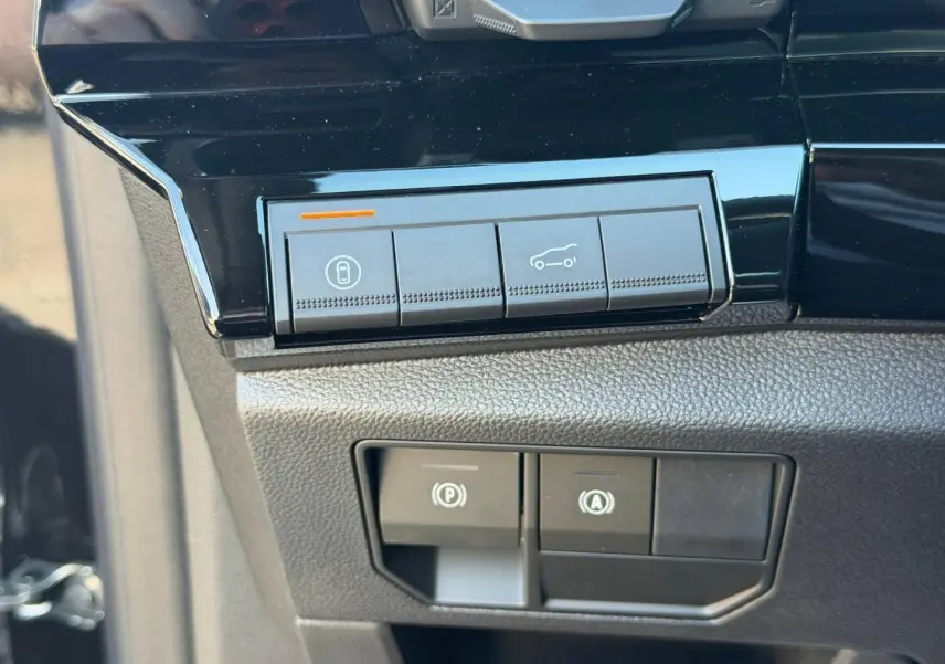 Gros plan sur les commandes noires brillantes du tableau de bord du Renault Austral 1.2 E-Tech noir étoilé.