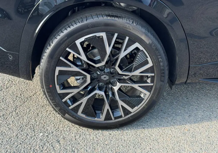Gros plan sur la jante alu noire et argentée du côté arrière droit du Renault Austral noir étoilé métallisé.