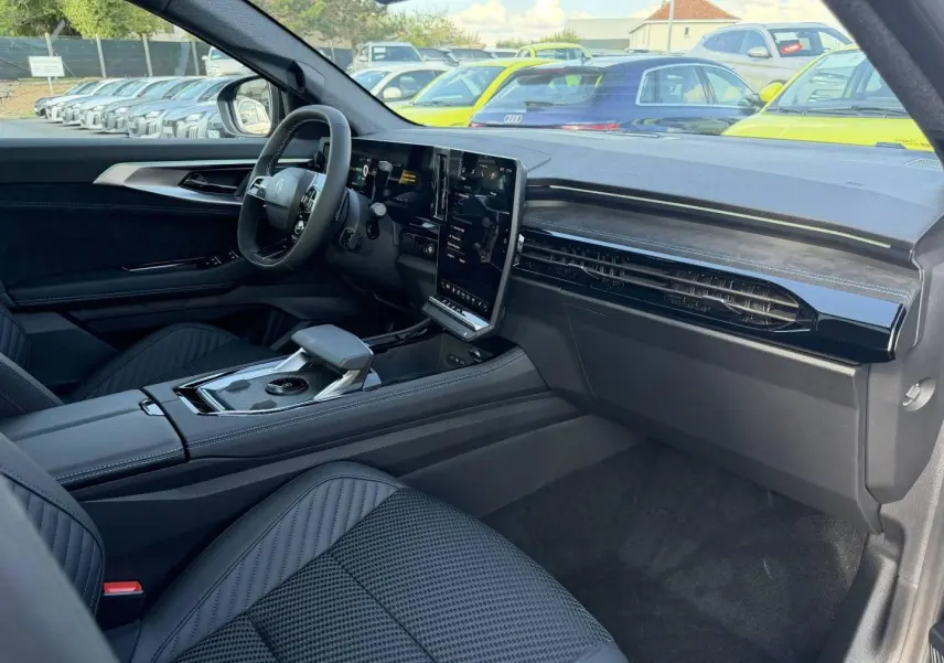 Intérieur avant droit du Renault Austral 2026 noir étoilé, avec écran tactile vertical et sièges en tissu carbone Alcantara.