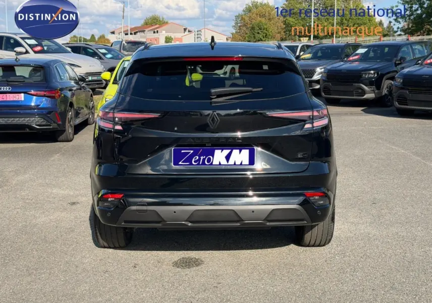 Vue arrière d'un Renault Austral noir étoilé métallisé garé sur un parking extérieur avec plusieurs véhicules autour.