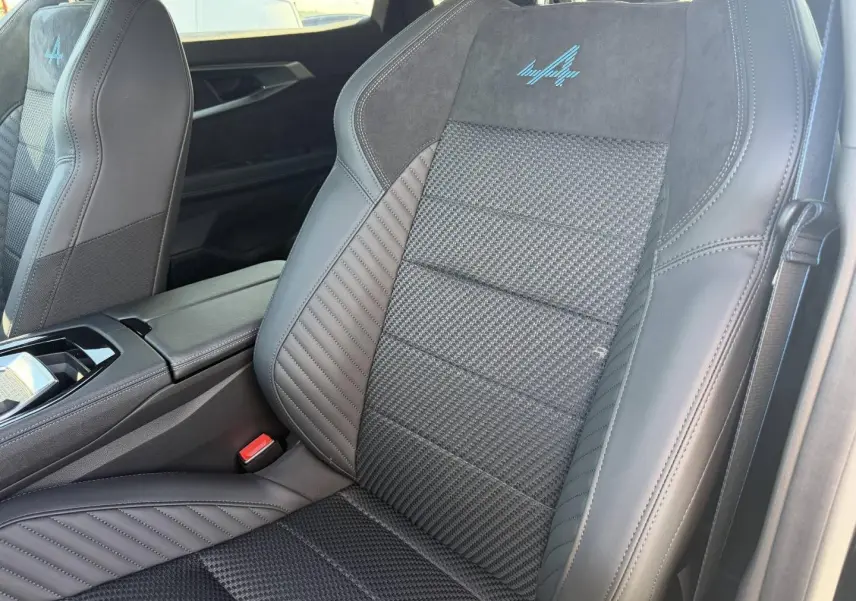 Gros plan sur les sièges avant noirs avec logo Alpine bleu, intérieur cuir et Alcantara du Renault Austral 2026.