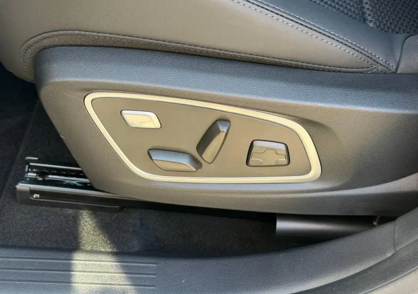Gros plan sur les commandes électriques de réglage du siège conducteur du Renault Austral noir étoilé.