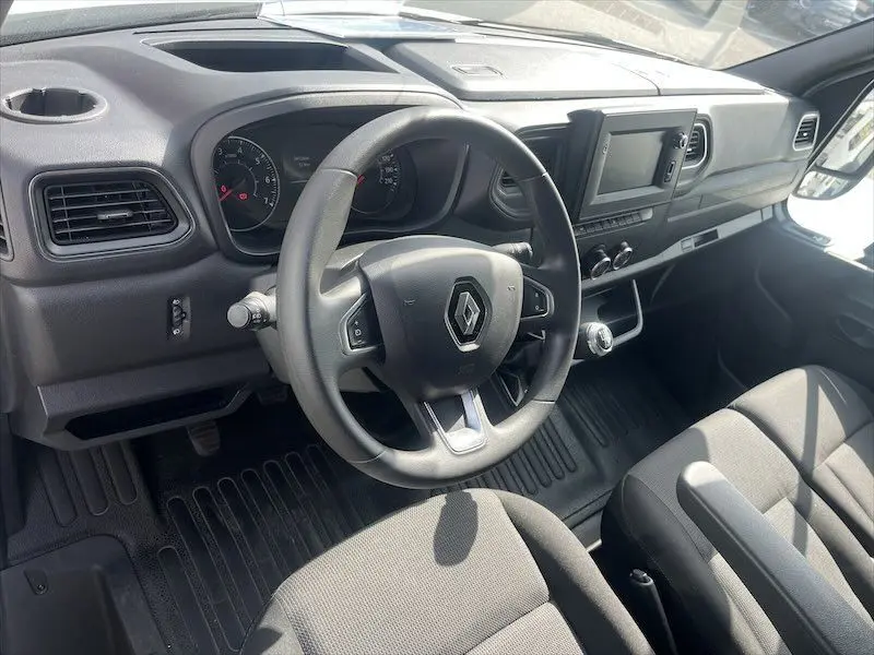 Vue intérieure du poste de conduite du Renault Master blanc 2021, avec volant multifonction et tableau de bord moderne.