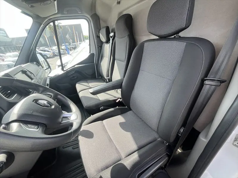 Intérieur du Renault Master blanc 2021, vue côté conducteur montrant les sièges gris et le volant avec logo Renault.