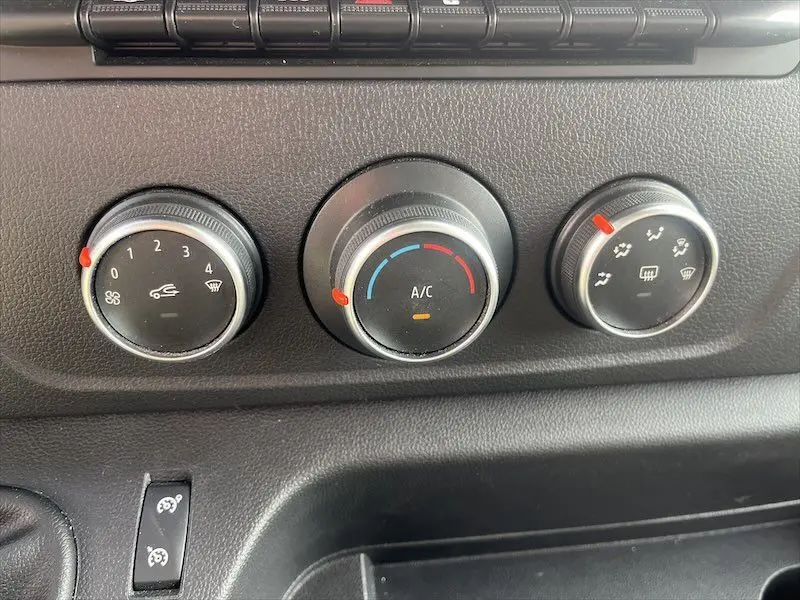 Gros plan sur les commandes de climatisation du Renault Master blanc 2021, avec réglages de ventilation, température et distribution d'air.