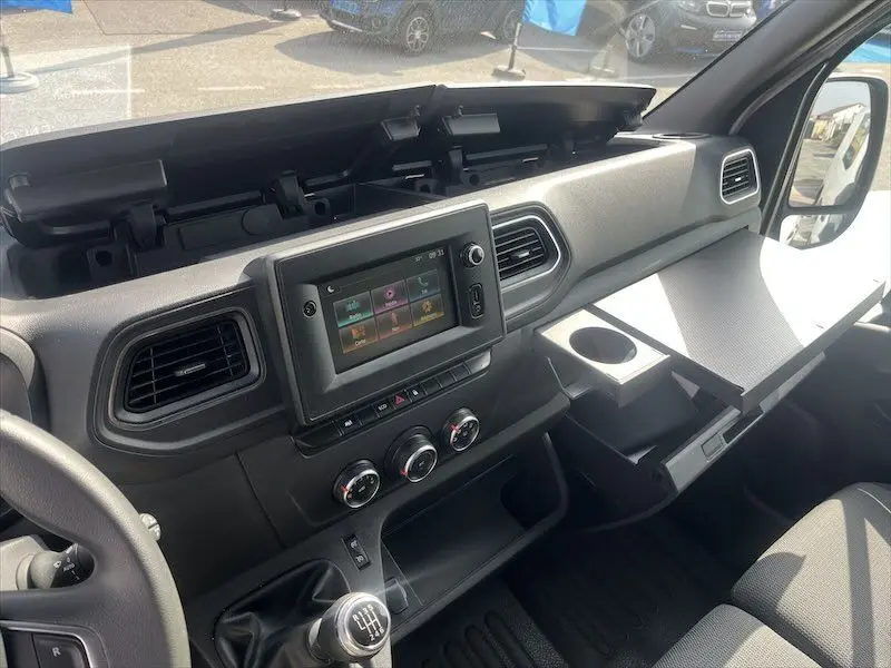 Intérieur du Renault Master 2.3 DCI 135 blanc, vue côté passager sur tableau de bord avec écran tactile et console ouverte.