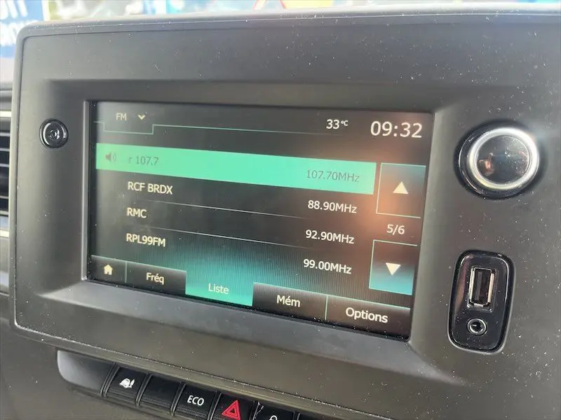 Écran tactile multimédia du tableau de bord du Renault Master blanc, affichant les stations radio FM et la température extérieure.