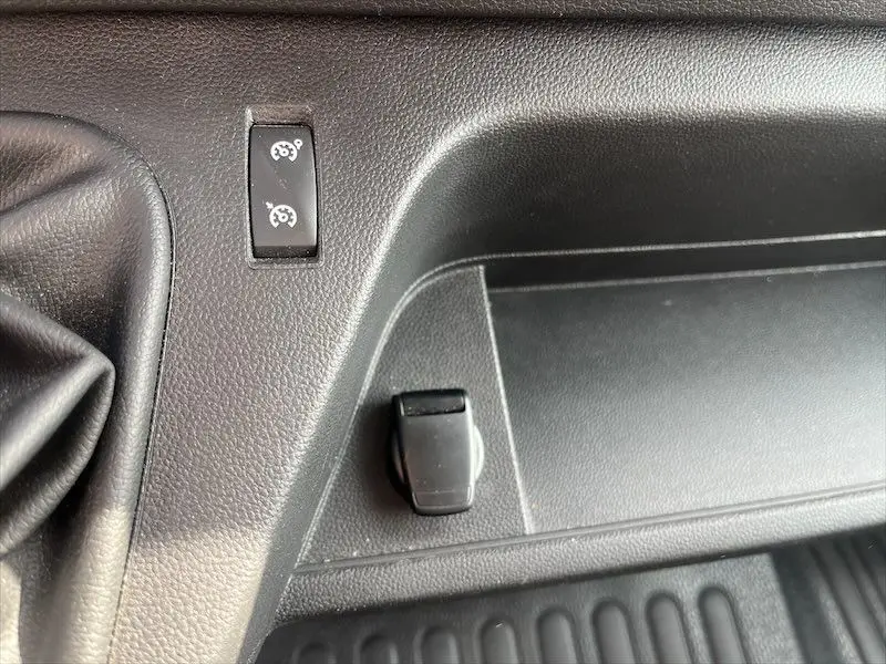 Gros plan sur le tableau de bord noir du Renault Master 2021 montrant les commandes de régulateur de vitesse et une prise accessoire.