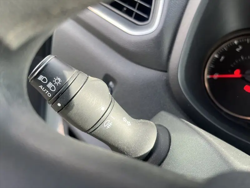 Gros plan sur la commande des phares automatiques à gauche du volant dans le tableau de bord du Renault Master blanc 2021.
