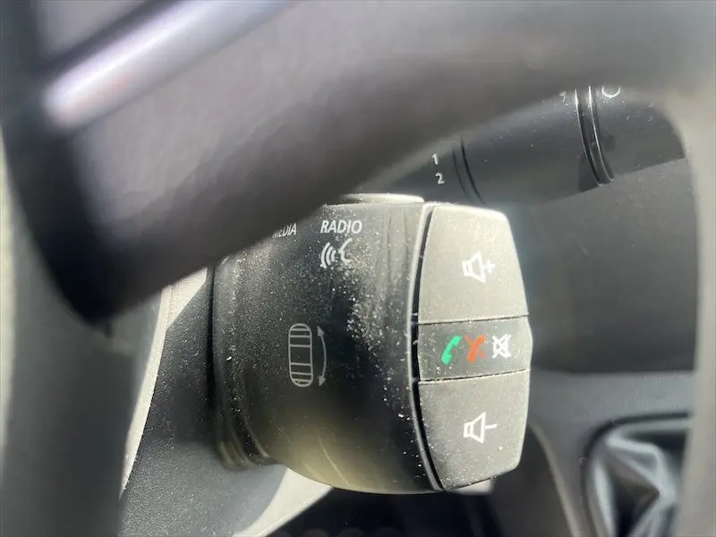 Gros plan sur les commandes audio et téléphone au volant du Renault Master blanc, version 2021, intérieur noir.