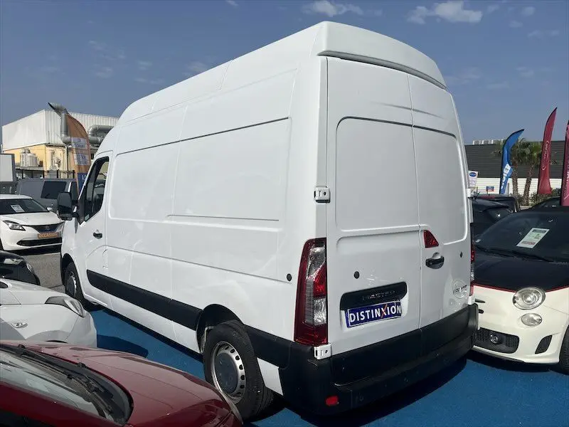 Renault Master blanc en vue 3/4 arrière droit, fourgon utilitaire grand volume avec toit surélevé, stationné en extérieur.
