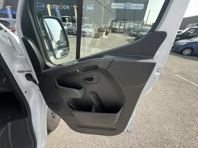 Vue rapprochée de la porte avant gauche ouverte du Renault Master blanc, mettant en valeur la garniture intérieure noire.