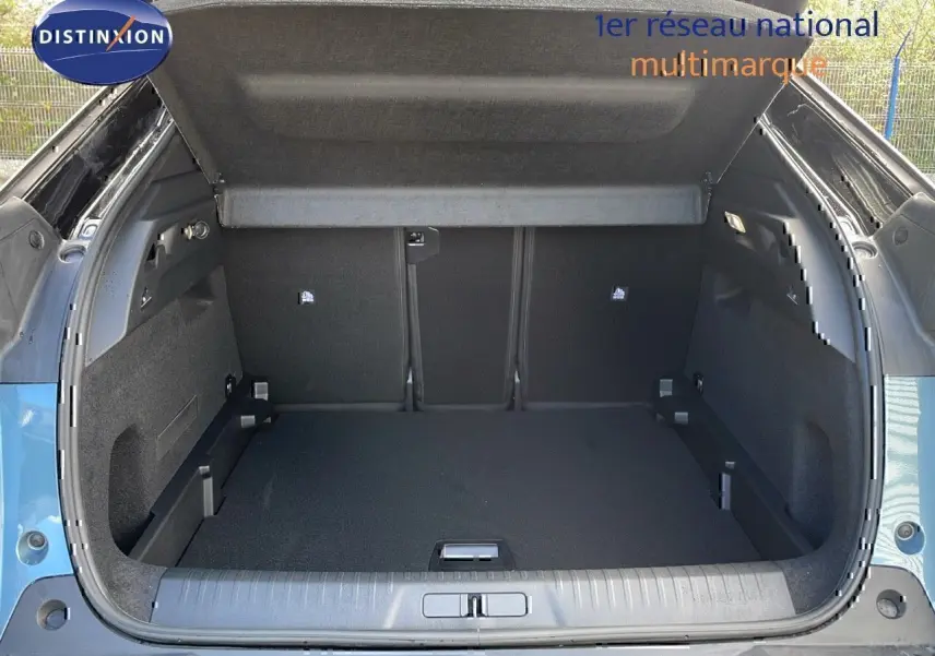 Coffre ouvert d’un Peugeot 3008 1.2 Hybrid 136ch GT bleu Ingaro métal avec toit noir, vue arrière dégagée.