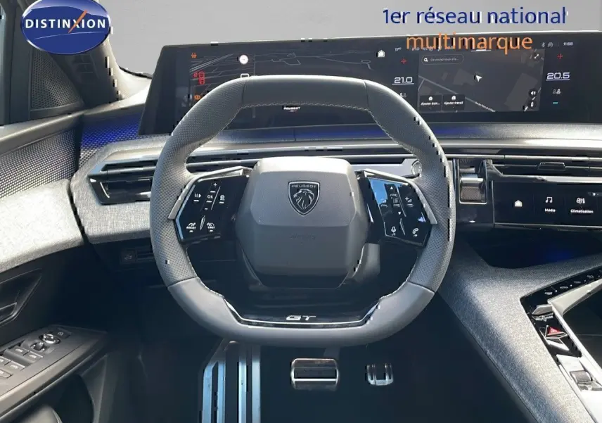 Vue intérieure centrée sur le volant GT en cuir noir du Peugeot 3008 1.2 Hybrid 2025 avec tableau de bord numérique.