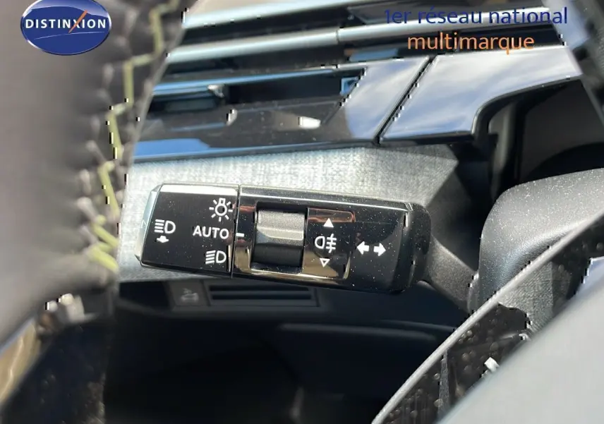 Gros plan sur la commande des feux et clignotants à gauche du volant dans l’habitacle du Peugeot 3008 bleu Ingaro 2025.