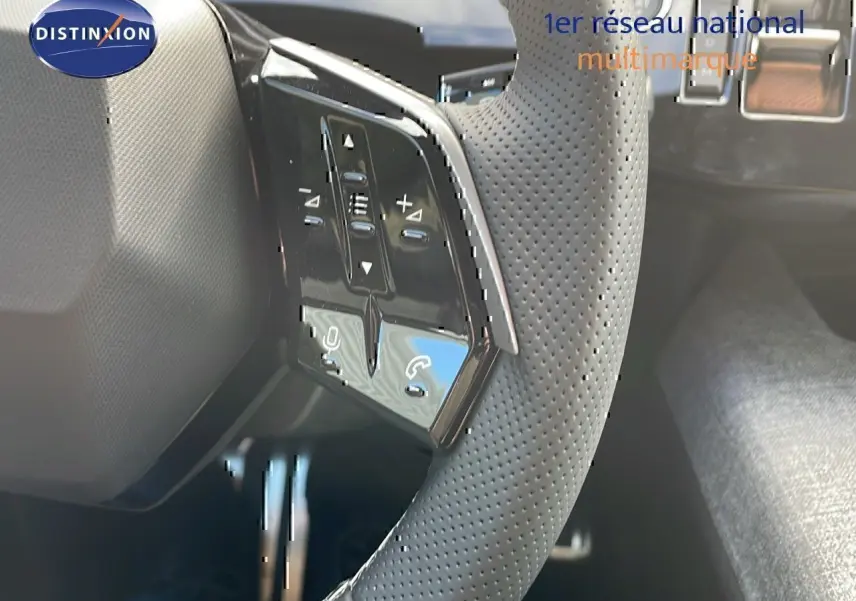 Gros plan sur le volant perforé avec commandes intégrées du Peugeot 3008 1.2 Hybrid 136ch GT, intérieur noir.