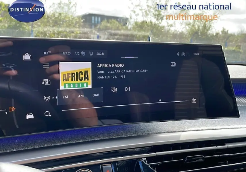 Vue intérieure du tableau de bord du Peugeot 3008 2025, écran tactile affichant la radio Africa Radio, ambiance moderne avec détails bleus.