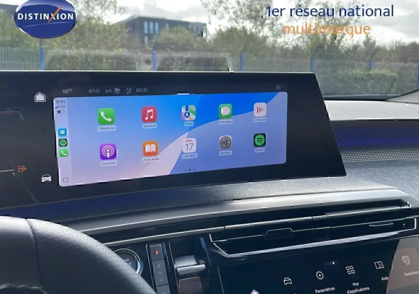 Vue intérieure du tableau de bord du Peugeot 3008 2025, écran tactile large affichant des applications, volant partiel visible.