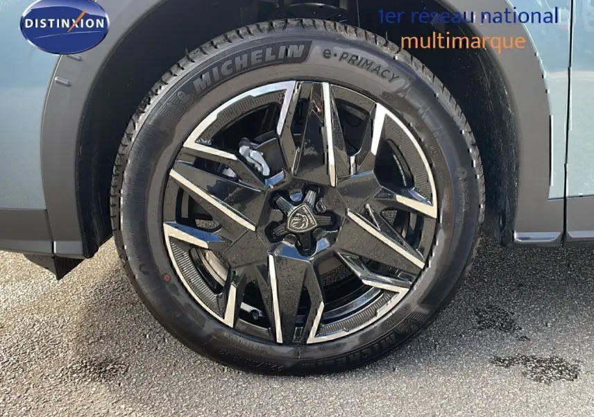 Gros plan sur la roue avant gauche du Peugeot 3008 1.2 Hybrid 136ch GT bleu Ingaro métal avec jante alliage noire et argentée.