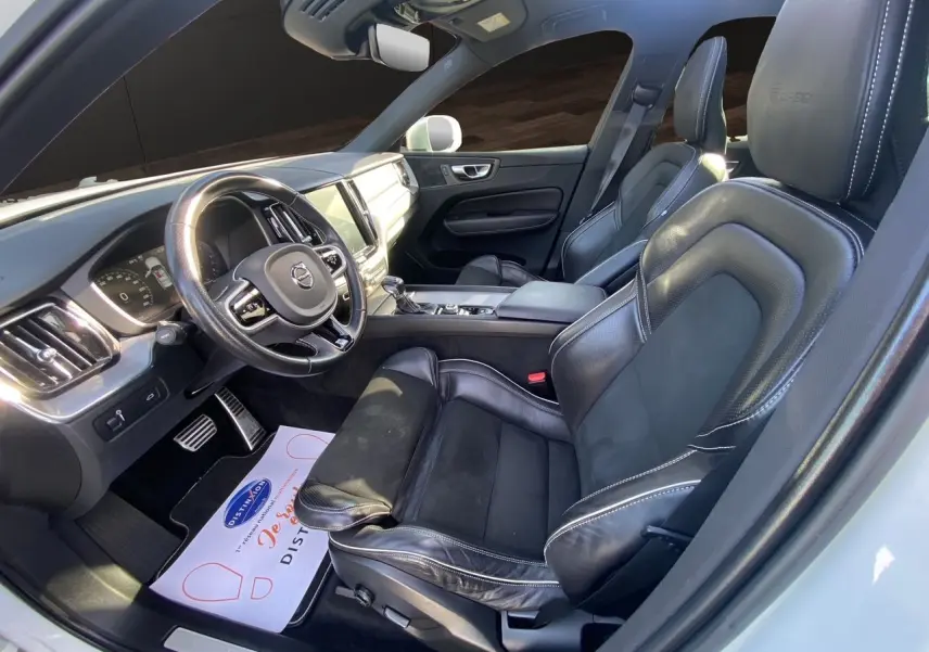 Intérieur noir cuir du Volvo XC60 D4 2019 vu côté conducteur, avec volant multifonction et tableau de bord moderne.