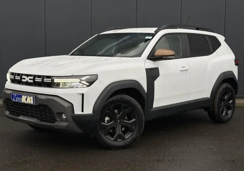 Vue 3/4 avant droite du Dacia Duster blanc Glacier avec coques de rétroviseurs brun cuivré et jantes noires.